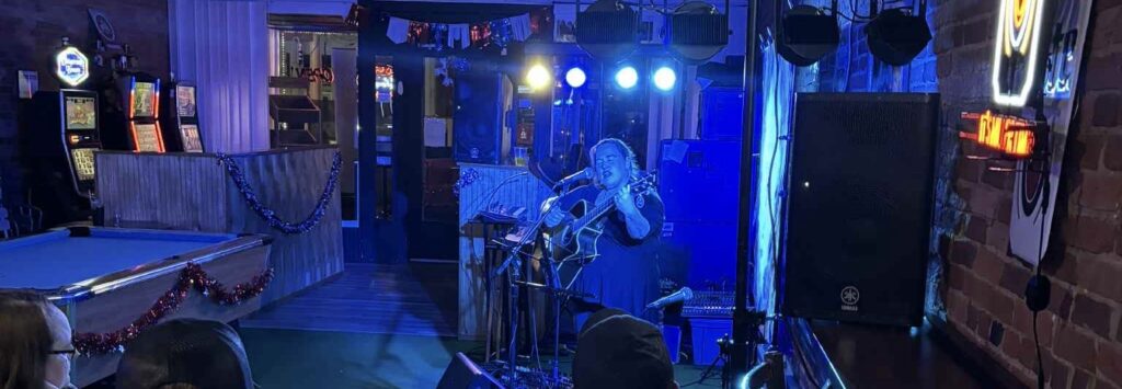 (wide angle) Bobbie JoEle performs for a crowd in a bar
